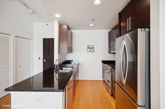 303 W Ohio St Unit 1509, Chicago, IL 60654 - kitchen with stainless steel appliances, a sink, a peninsula, light wood-type flooring, and baseboards