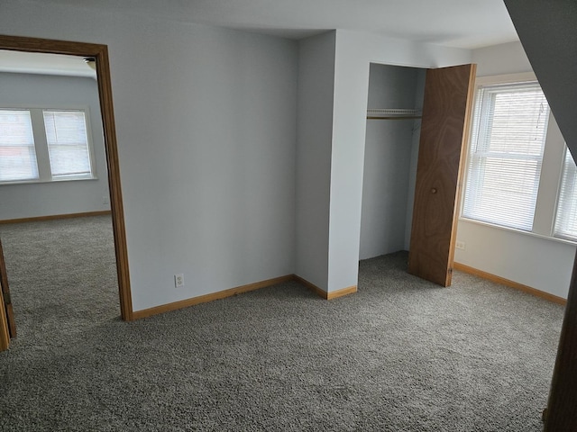 unfurnished bedroom featuring carpet floors, a closet, and baseboards