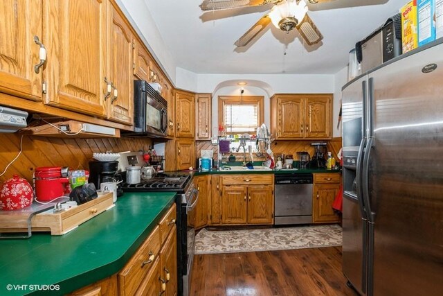 9230 S Saint Louis Ave, Evergreen Park, IL 60805 - kitchen with appliances with stainless steel finishes, brown cabinetry, dark wood-style floors, a ceiling fan, and dark countertops