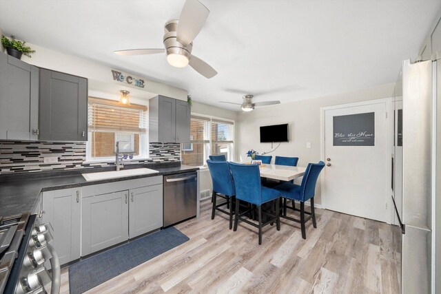 9656 S Utica Ave, Evergreen Park, IL 60805 - kitchen with appliances with stainless steel finishes, a sink, ceiling fan, decorative backsplash, and dark countertops