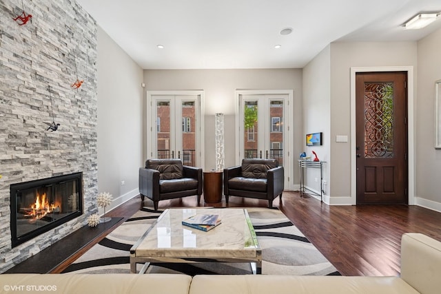 living area featuring french doors, wood finished floors, a fireplace, baseboards, and recessed lighting
