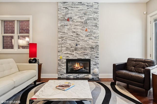 living room featuring wood finished floors, a fireplace, and baseboards