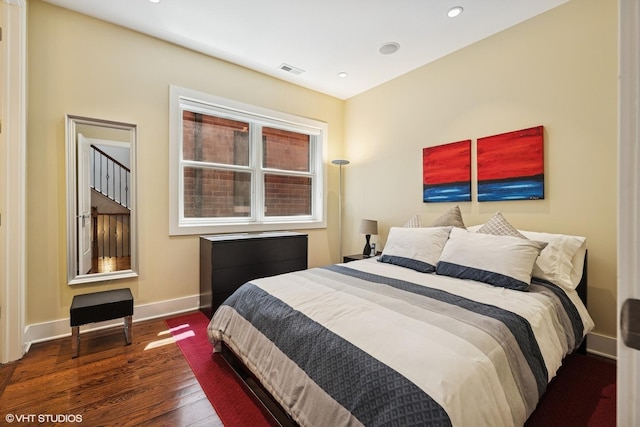 bedroom featuring wood finished floors, baseboards, and recessed lighting