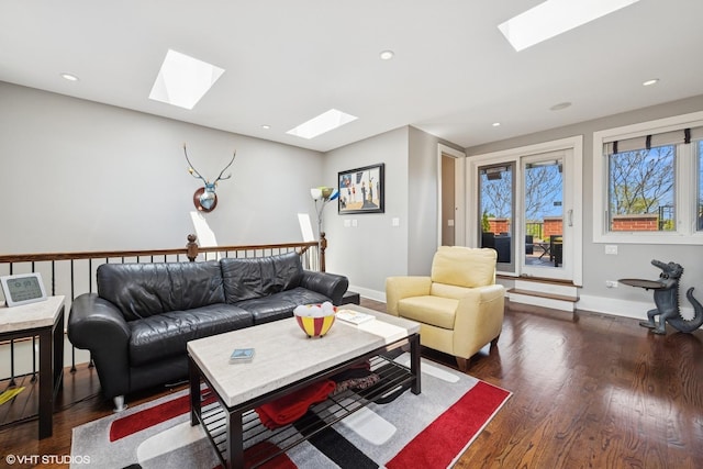 living room with a skylight, dark wood-style flooring, baseboards, and recessed lighting