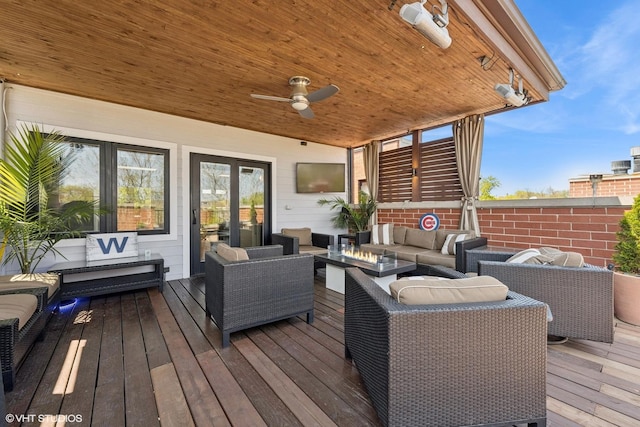 wooden terrace featuring outdoor lounge area and a ceiling fan