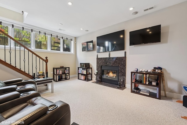 carpeted living area with a high end fireplace, stairs, baseboards, and recessed lighting
