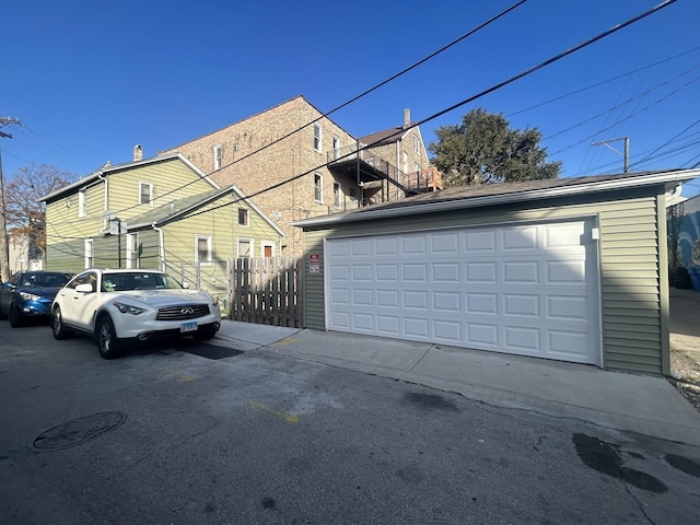 view of side of home with a garage and fence