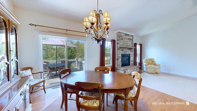 1400 Colchester Ln, Aurora, IL 60505 - dining area featuring a chandelier, a stone fireplace, light wood-style flooring, and lofted ceiling