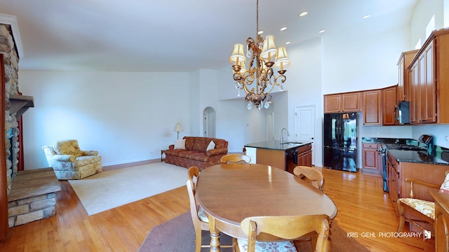 1400 Colchester Ln, Aurora, IL 60505 - dining area featuring arched walkways, light wood-type flooring, a chandelier, a towering ceiling, and recessed lighting