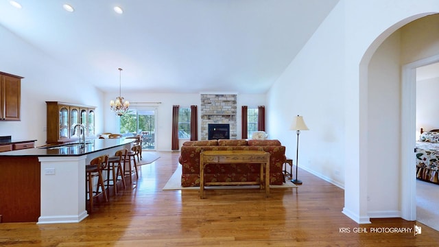 1400 Colchester Ln, Aurora, IL 60505 - living area with light wood-style floors, baseboards, a fireplace, recessed lighting, and arched walkways