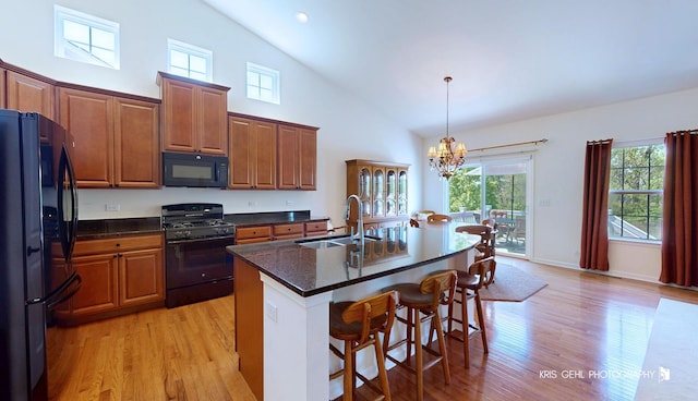 1400 Colchester Ln, Aurora, IL 60505 - kitchen featuring black appliances, a sink, a chandelier, light wood-type flooring, and high vaulted ceiling