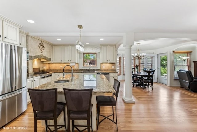 506 Rodney St, Lockport, IL 60441 - kitchen with stainless steel appliances, a sink, arched walkways, ornate columns, and a chandelier