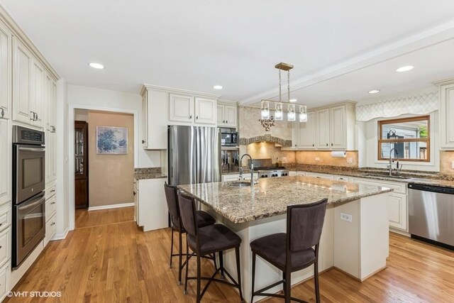 506 Rodney St, Lockport, IL 60441 - kitchen featuring appliances with stainless steel finishes, a sink, light wood-type flooring, a breakfast bar area, and recessed lighting
