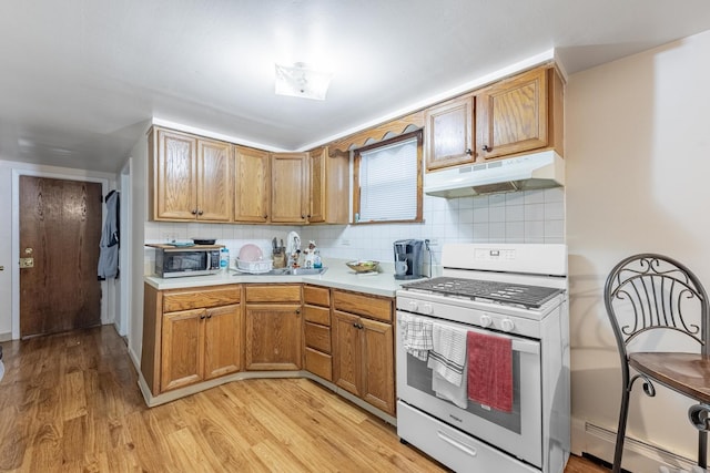 7426 W 64th St, Summit, IL 60501 - kitchen featuring gas range gas stove, under cabinet range hood, a baseboard radiator, light wood-style floors, and light countertops