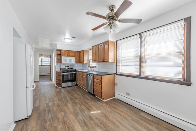 7426 W 64th St, Summit, IL 60501 - kitchen with stainless steel appliances, baseboard heating, a ceiling fan, and brown cabinetry