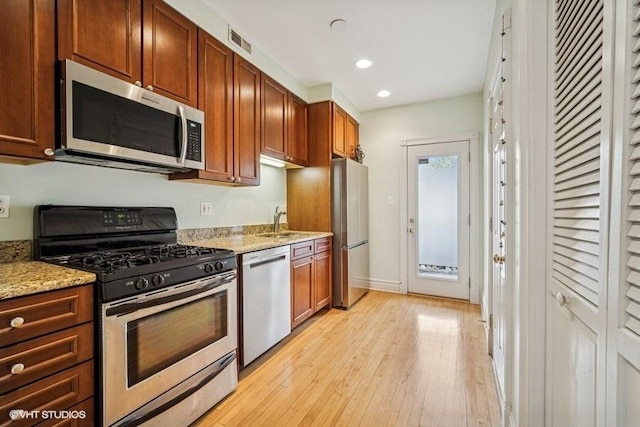 4444 N Wolcott Ave Unit 2A, Chicago, IL 60640 - kitchen featuring appliances with stainless steel finishes, light wood finished floors, a sink, light stone countertops, and recessed lighting