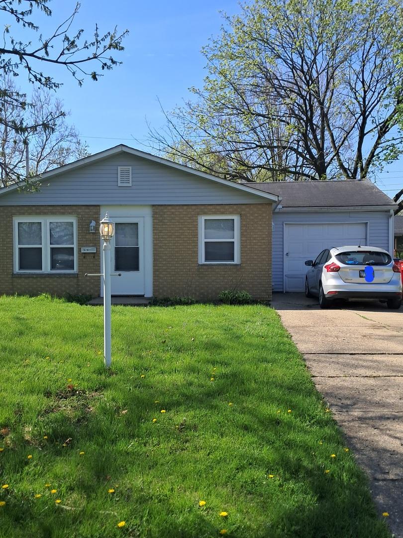 1615 W Lock Raven Rd, Champaign, IL 61821 - single story home featuring a garage, brick siding, concrete driveway, and a front yard