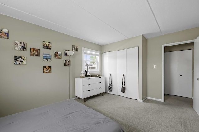 bedroom with light colored carpet, a closet, and baseboards