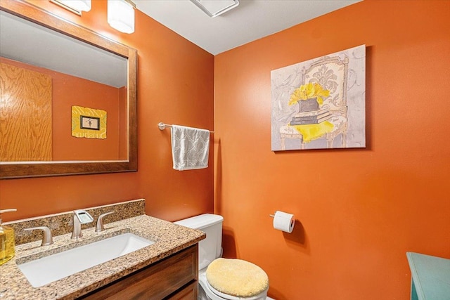 half bath featuring toilet and vanity