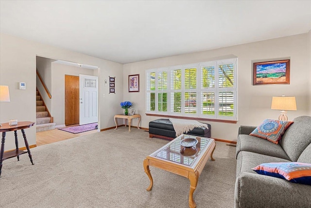 living room with baseboards, stairs, and carpet flooring