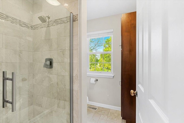 bathroom featuring a stall shower, baseboards, and toilet