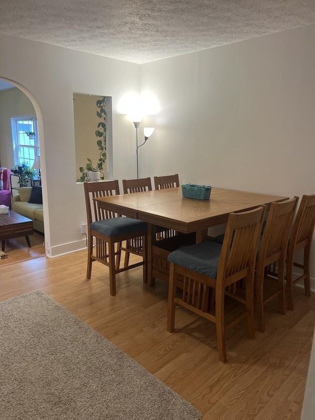 833 S 5th Ave, Kankakee, IL 60901 - dining space with light wood-type flooring, a textured ceiling, arched walkways, and baseboards