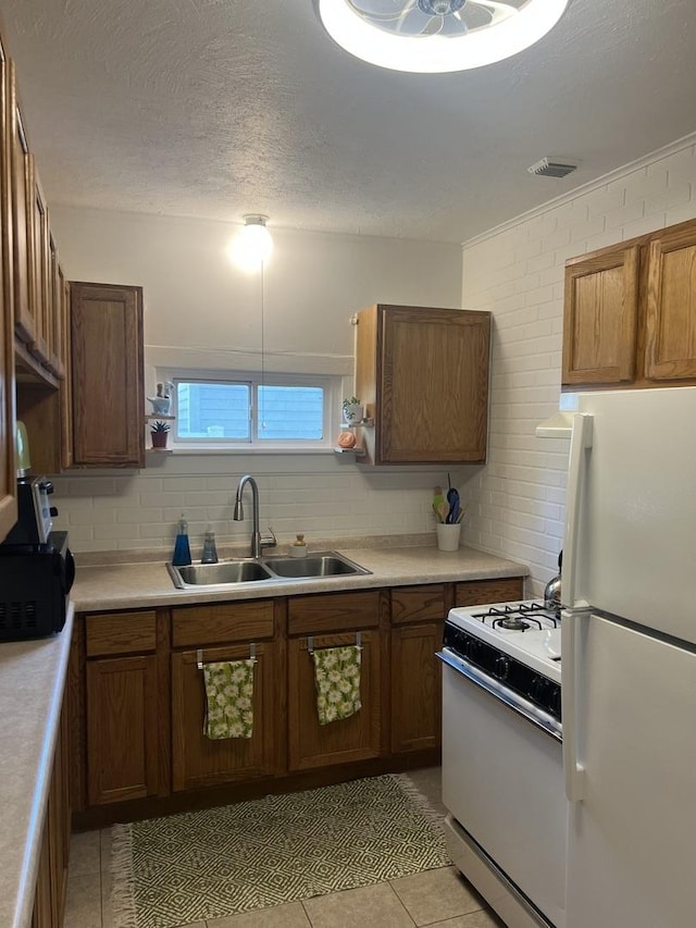 833 S 5th Ave, Kankakee, IL 60901 - kitchen with white appliances, a sink, light tile patterned floors, light countertops, and a textured ceiling