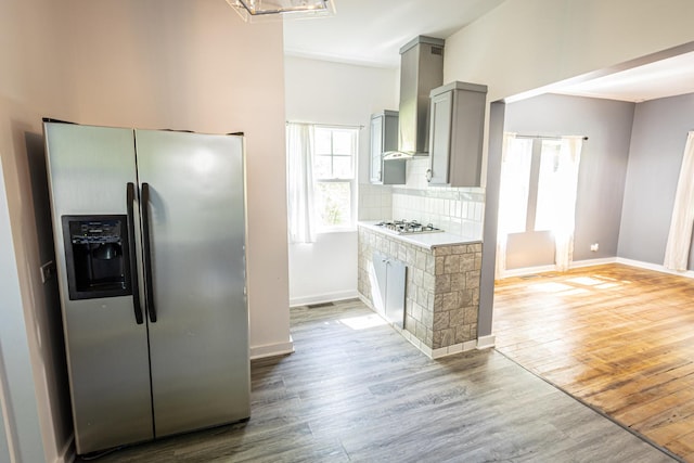 684 S Gordon Ave, Kankakee, IL 60901 - kitchen with stainless steel fridge with ice dispenser, gray cabinetry, wall chimney exhaust hood, white gas cooktop, and wood finished floors