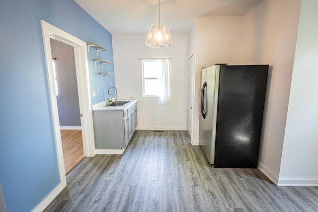684 S Gordon Ave, Kankakee, IL 60901 - kitchen featuring freestanding refrigerator, wood finished floors, a sink, open shelves, and light countertops