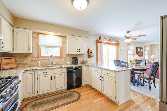 43 Mohawk St, Cary, IL 60013 - kitchen featuring black dishwasher, a sink, a peninsula, decorative backsplash, and light stone counters