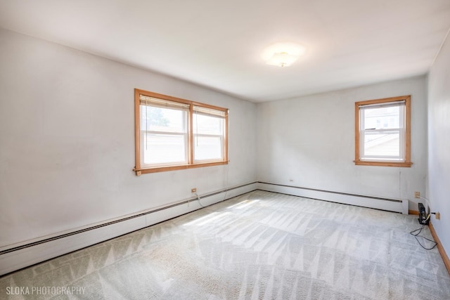 spare room featuring carpet flooring, plenty of natural light, baseboards, and baseboard heating