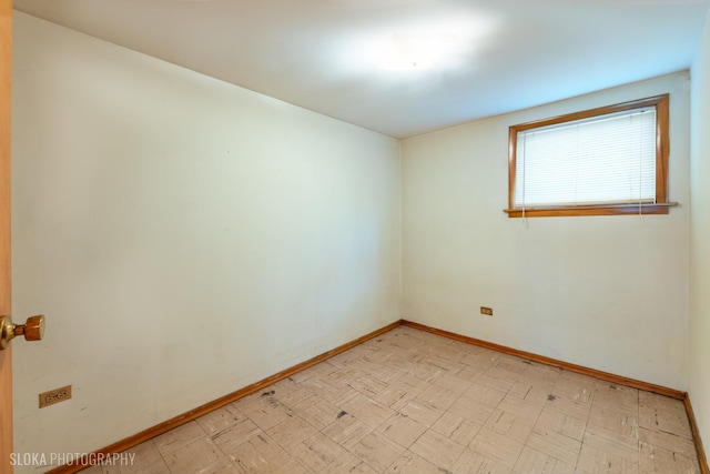 spare room featuring baseboards and light flooring