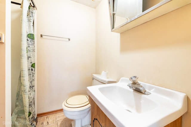 bathroom featuring toilet, a sink, baseboards, a shower with curtain, and wood finished floors