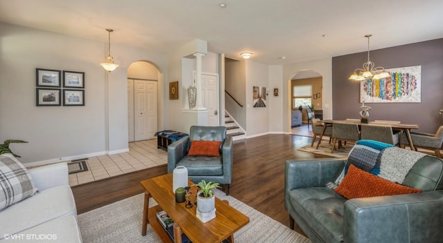 2140 Colchester Ave, Hoffman Estates, IL 60192 - living area featuring arched walkways, wood finished floors, stairs, a chandelier, and baseboards