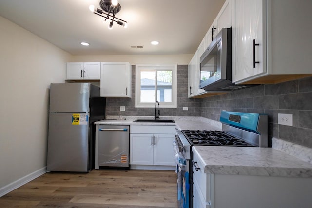 239 Marquette St, Park Forest, IL 60466 - kitchen with stainless steel appliances, a sink, light wood-type flooring, white cabinets, and recessed lighting