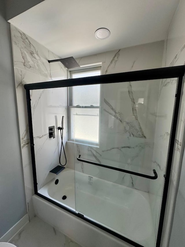 bathroom featuring bath / shower combo with glass door and marble finish flooring