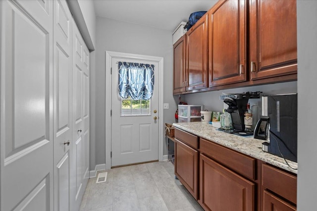 laundry area featuring light tile patterned floors and baseboards