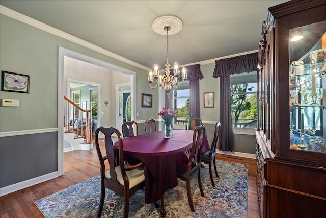 dining space with a chandelier, baseboards, wood finished floors, stairway, and ornamental molding