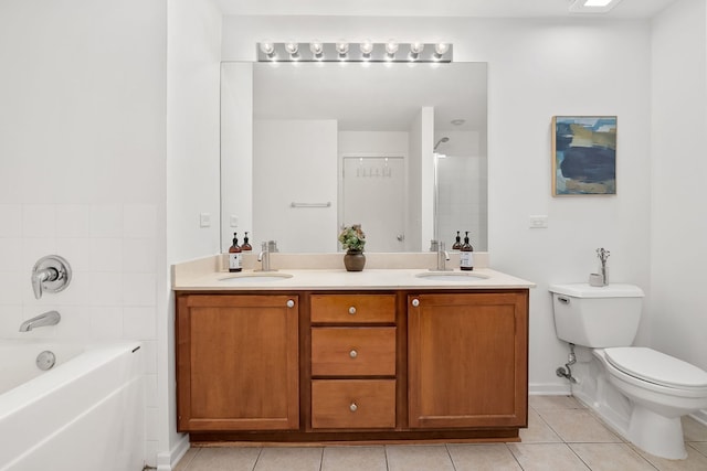 full bath with tile patterned floors, toilet, double vanity, a tub, and baseboards