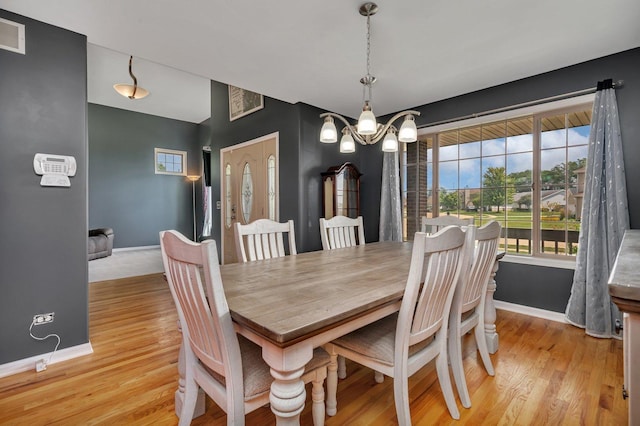 203 Jefferson St, Manteno, IL 60950 - dining area featuring baseboards, light wood-type flooring, and a chandelier