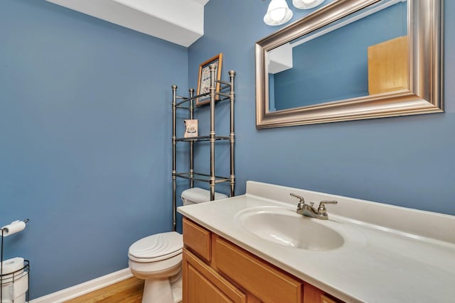203 Jefferson St, Manteno, IL 60950 - half bathroom with toilet, vanity, wood finished floors, and baseboards