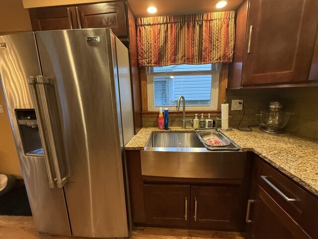 8325 W Maple Ave, Norridge, IL 60706 - kitchen featuring stainless steel refrigerator with ice dispenser, a sink, light stone counters, decorative backsplash, and dark brown cabinets