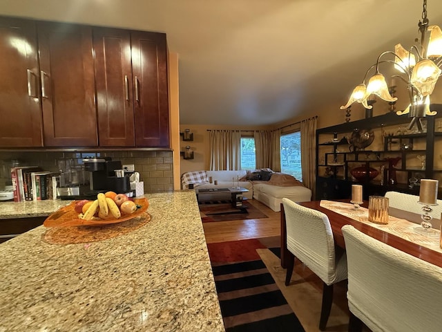 8325 W Maple Ave, Norridge, IL 60706 - kitchen with a chandelier, open floor plan, tasteful backsplash, light stone counters, and dark wood-type flooring