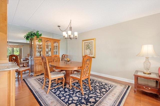 dining area with a chandelier and light wood-style flooring