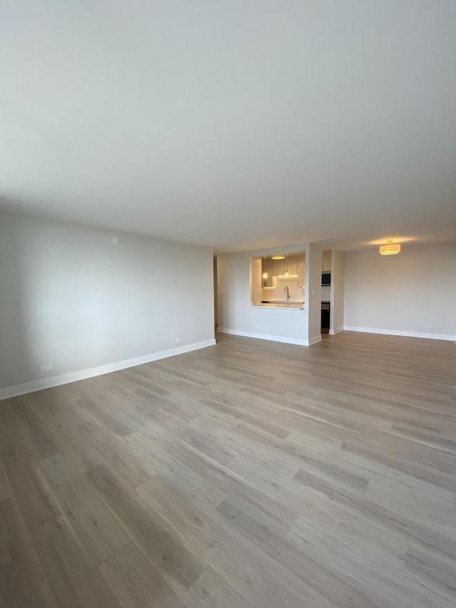 3930 N Pine Grove Ave Unit 1703, Chicago, IL 60613 - unfurnished living room with light wood-style flooring and baseboards