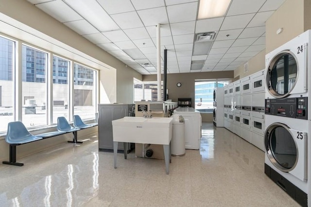 community laundry room with estacked washer and dryer and washing machine and clothes dryer