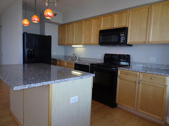 kitchen with black appliances, light wood finished floors, light brown cabinets, stone countertops, and a center island