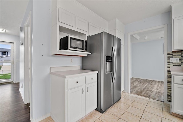 408 Lake Shore Cir, Bloomington, IL 61704 - kitchen featuring appliances with stainless steel finishes, white cabinetry, light countertops, light wood finished floors, and tasteful backsplash