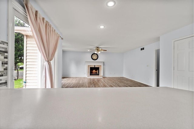 408 Lake Shore Cir, Bloomington, IL 61704 - unfurnished living room with ceiling fan, a high end fireplace, recessed lighting, and wood finished floors