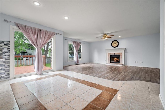 408 Lake Shore Cir, Bloomington, IL 61704 - unfurnished living room with tile patterned flooring, a ceiling fan, plenty of natural light, a premium fireplace, and recessed lighting